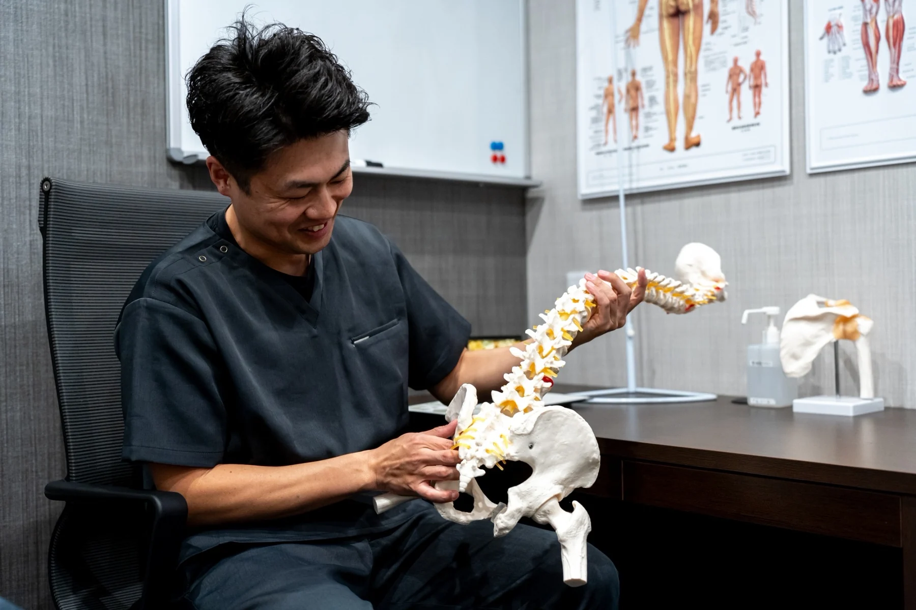 整体院NEOで骨盤と背骨の模型を使って説明する様子